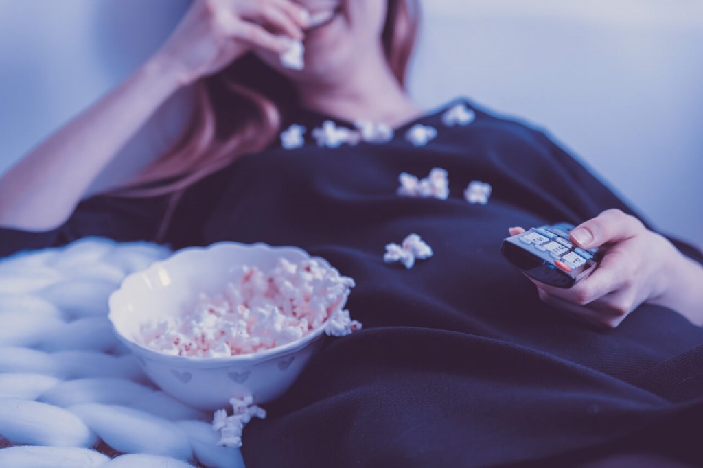 Mulher, assistindo filme e comendo pipoca