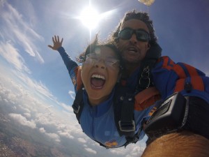 Mulher em esportes de aventura saltando de paraquedas com o instrutor