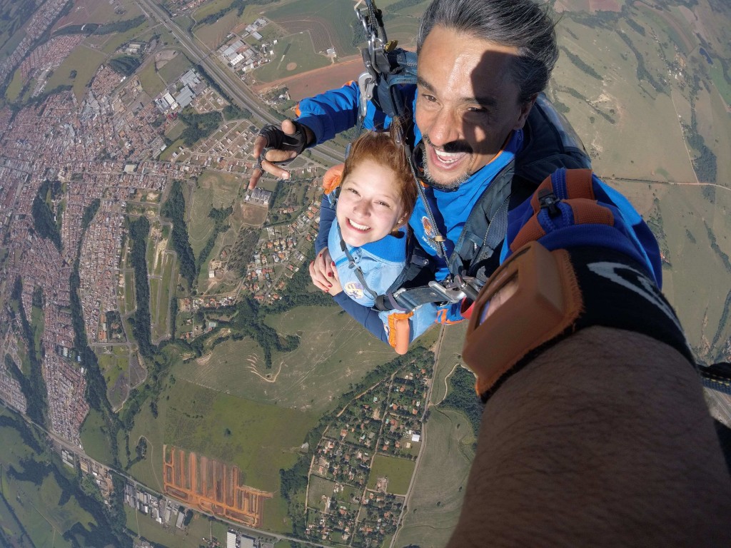 Jovem em salto duplo com instrutor no Centro Nacional de Paraquedismo