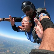 Mulher com instrutor em salto de paraquedas