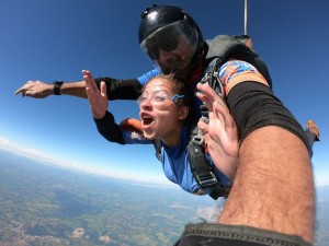 Mulher com instrutor em salto de paraquedas