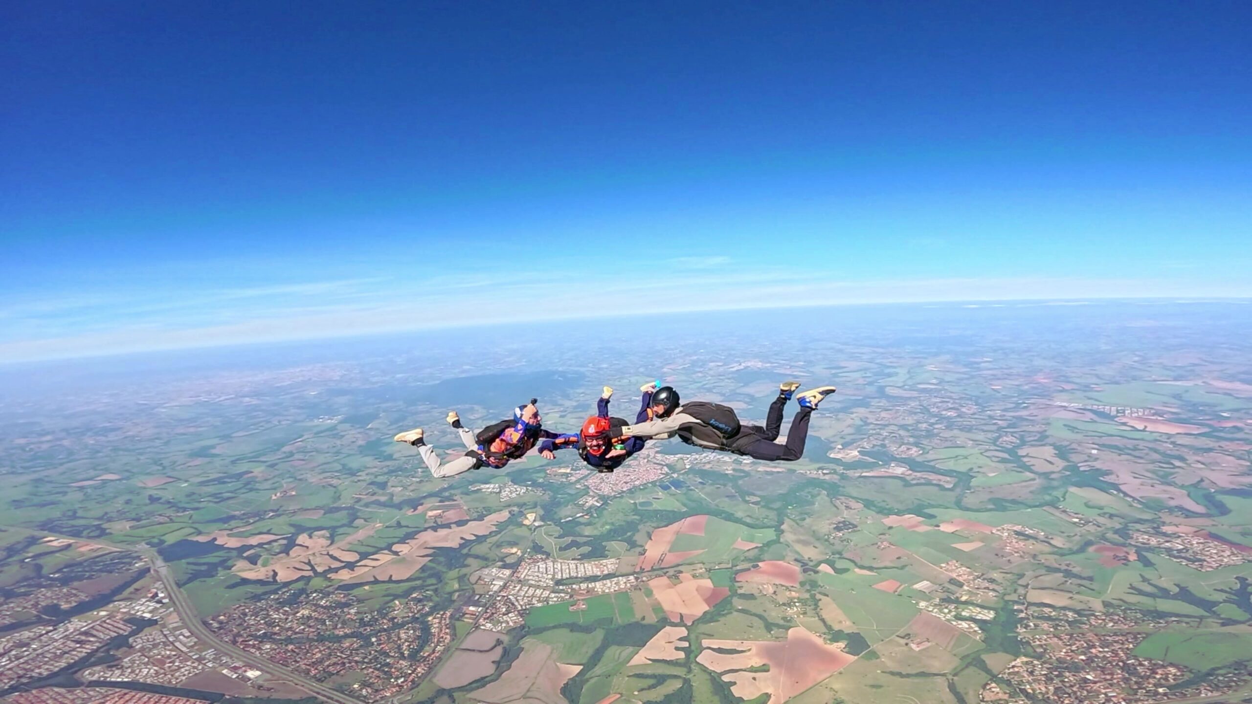 Três paraquedistas em queda livre.