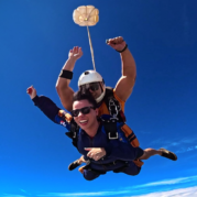 Instrutor de paraquedismo e aluna em queda livre durante salto de paraquedas, destino ideal para suas férias de julho