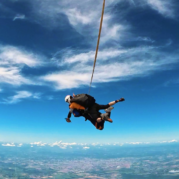 Duas pessoas em queda livre durante salto de paraquedas, exemplo de atividades para praticar no frio