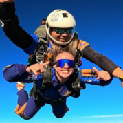 Instrutor de paraquedismo e aluna em queda livre durante salto duplo de paraquedas
