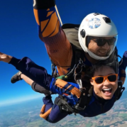 Instrutor de paraquedismo e aluna em queda livre durante salto de paraquedas