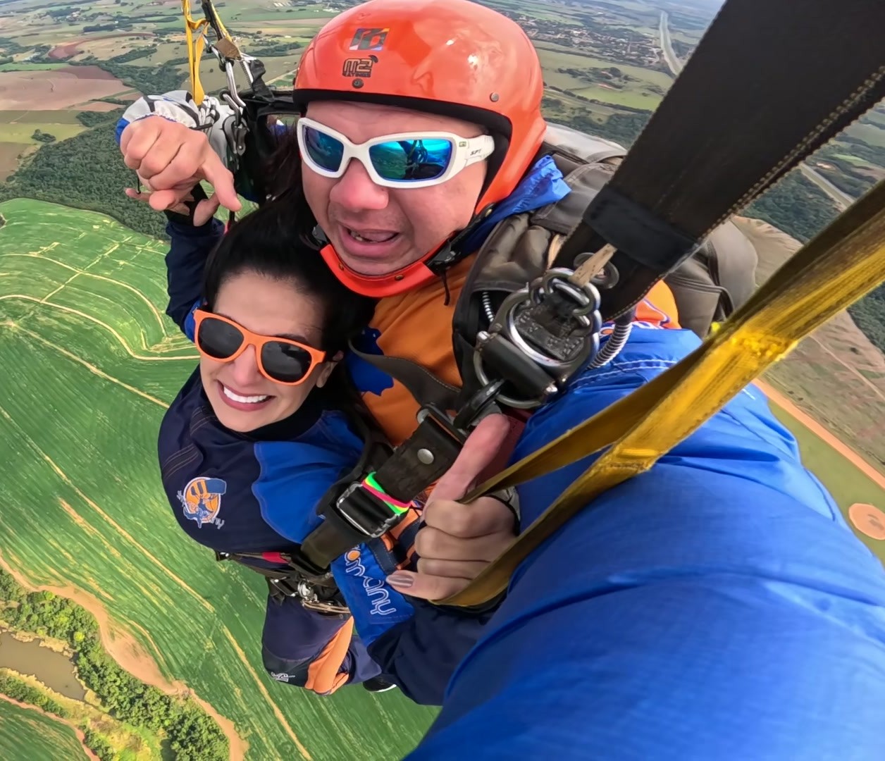 Parapente sobre paisagem verdejante.