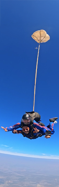 Pessoas saltando de paraquedas no céu.
