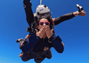 Instrutor de paraquedismo e aluna em queda livre durante salto duplo de paraquedas