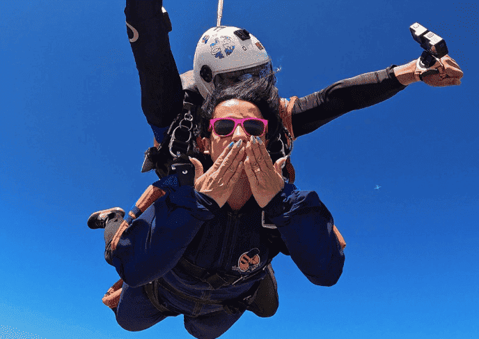 Instrutor de paraquedismo e aluna em queda livre durante salto duplo de paraquedas