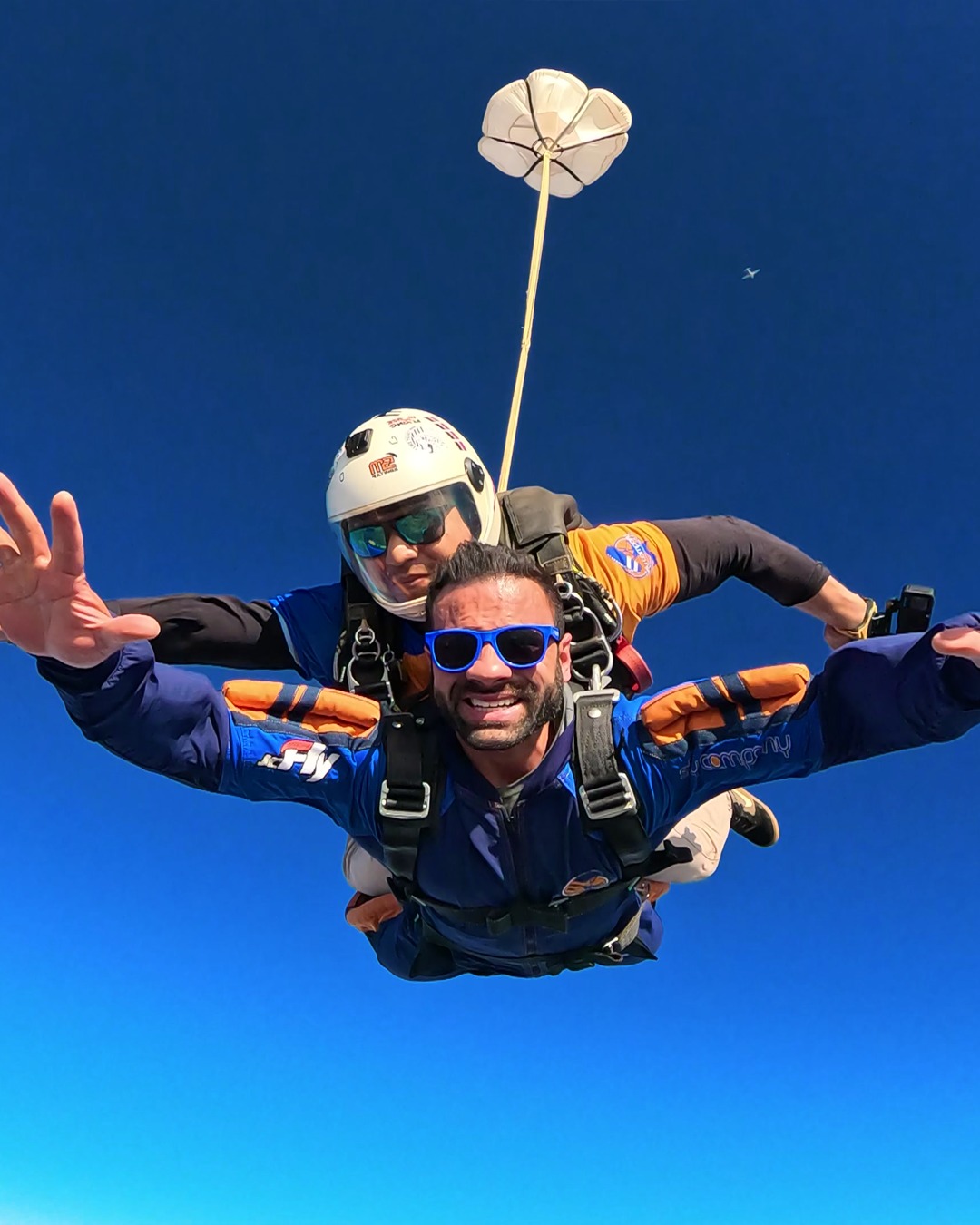 Instrutor de paraquedismo e aluno em queda livre após saltar de paraquedas