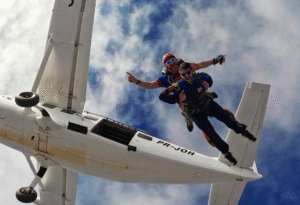 Instrutor de paraquedismo e aluno em queda livre durante salto duplo