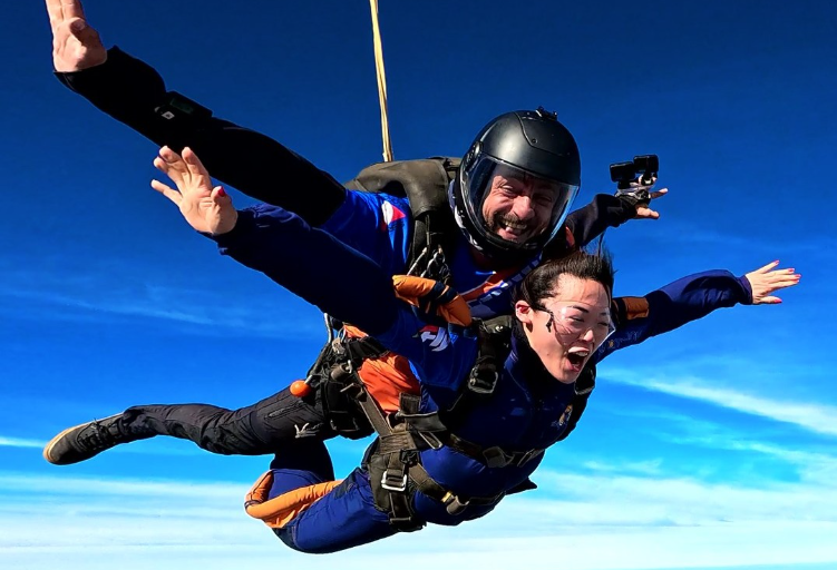 Instrutor de paraquedismo e aluna em queda livre durante salto duplo