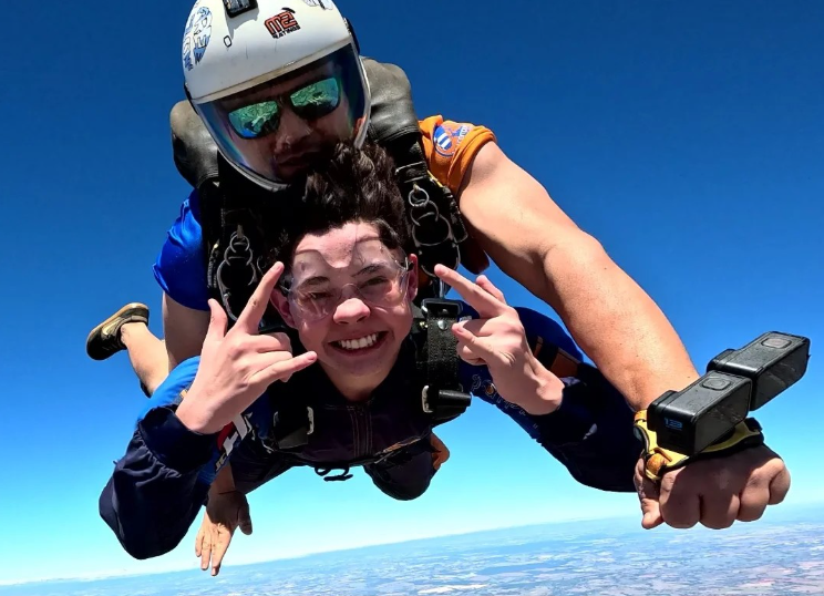 Instrutor de paraquedismo e aluna em queda livre durante salto de paraquedas