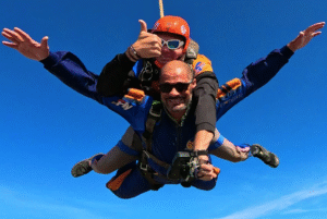 Instrutor de paraquedismo e aluno praticando experiências radicais ao saltar de paraquedas