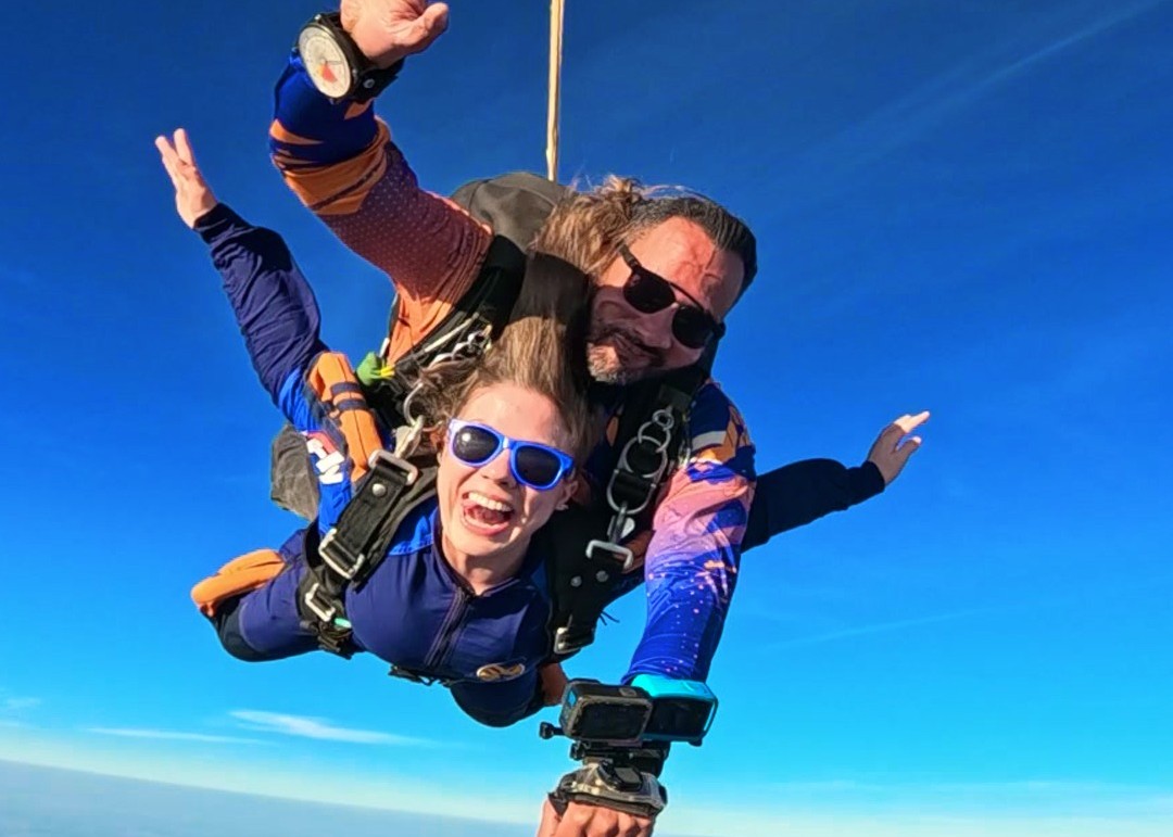 Instrutor e aluna em queda livre durante salto de paraquedas