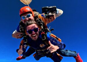 Instrutor de paraquedismo e aluno em queda livre durante salto de paraquedas