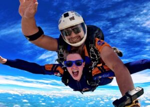 Instrutor e aluna durante queda livre após pular de paraquedas