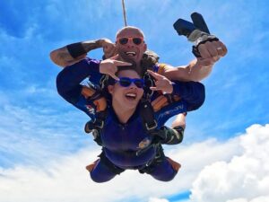 Instrutor de paraquedismo e aluna durante salto duplo