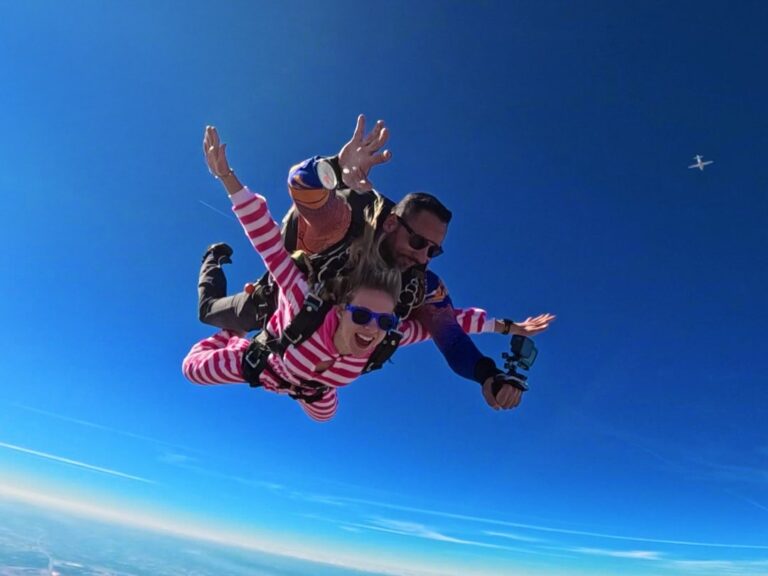 Instrutor de paraquedismo e aluna em queda livre durante salto duplo