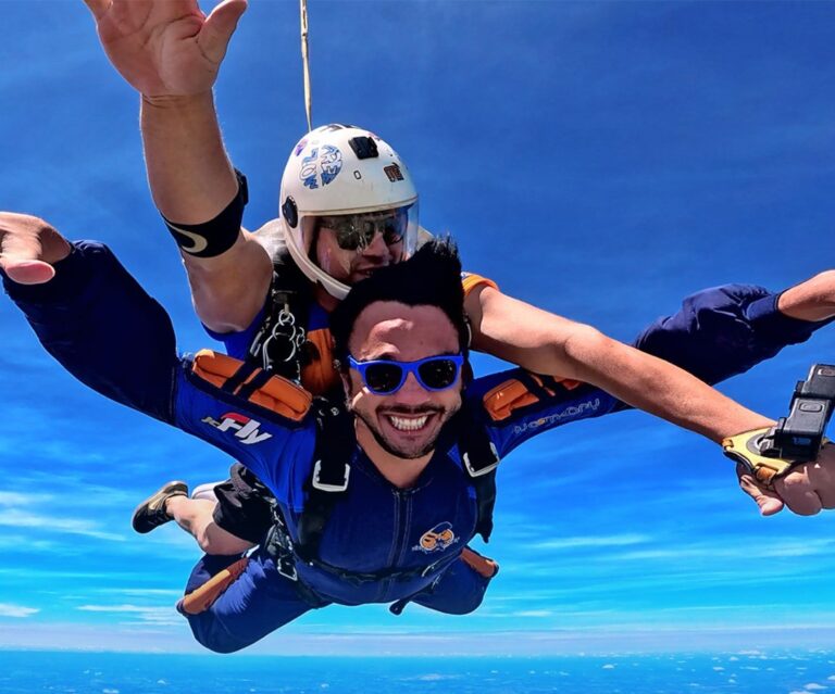 Instrutor de paraquedismo e aluno em queda livre após saltar de paraquedas