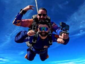 Instrutor de paraquedismo e aluno durante salto de paraquedas do curso AFF