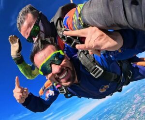 Aluno e instrutor de paraquedismo durante salto duplo de paraquedas