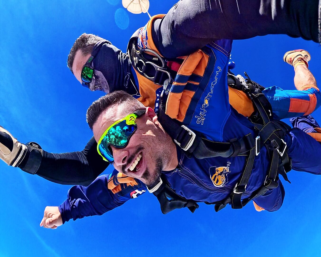 Instrutor de paraquedismo e aluno durante salto de paraquedas.