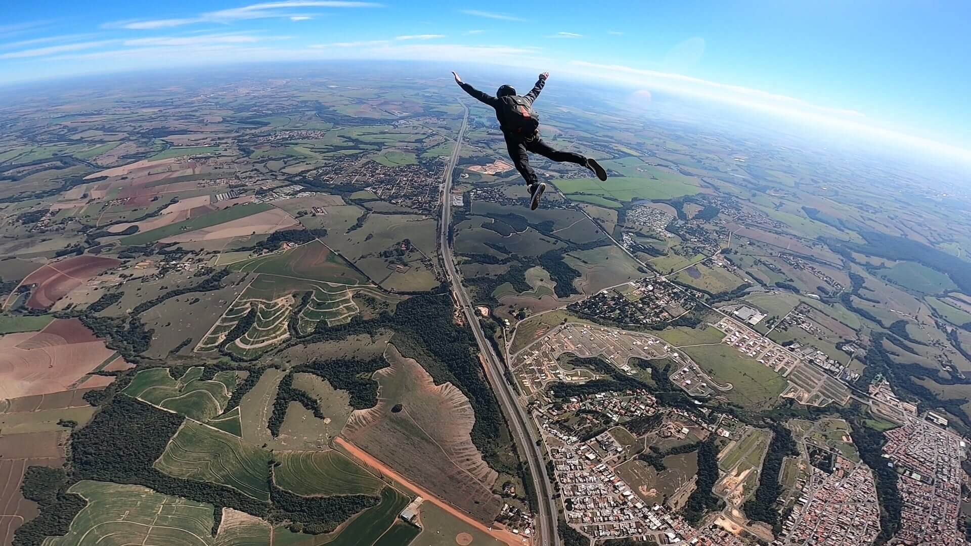 Paraquedista em queda livre após salto solo de paraquedas.