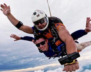 Instrutor de paraquedismo e aluna durante salto de paraquedas