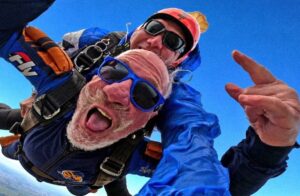 Instrutor de paraquedismo e aluno em queda livre durante o salto tandem