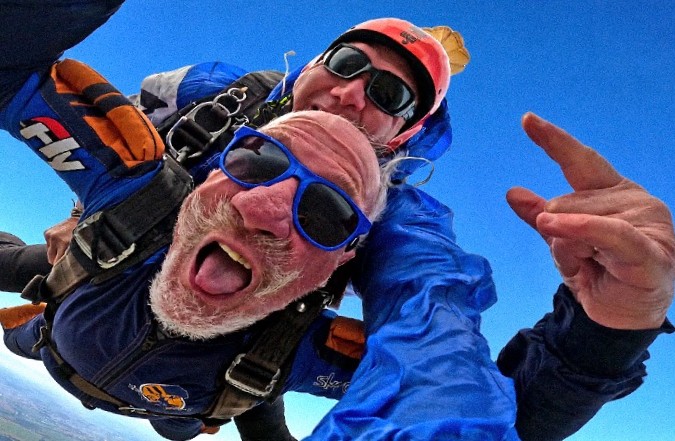 Instrutor de paraquedismo e aluno em queda livre durante o salto tandem
